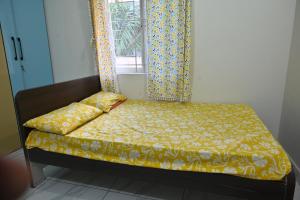 1 cama con edredón amarillo y ventana en Koneru's Village Stay - Hampi "Workcation", en Munirābād