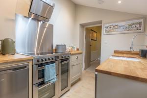 a kitchen with a stainless steel stove and a sink at Cozy Cottage, Wrington in Wrington