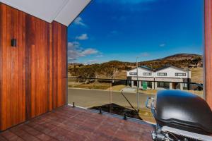 a balcony with a view of a house at Rawson Retreat - Spa, EV outlet and Premium Luxury in Jindabyne