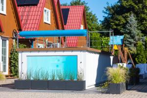 a large swimming pool in front of a house at Kompleks Wypoczynkowy Pomerania z podgrzewanym basenem 30 metrów do morza in Rewal
