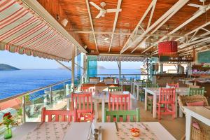 a restaurant with tables and chairs and the ocean at Hotel Sonne - Adults Only in Kaş