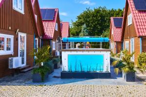 a swimming pool in the middle of a row of houses at Kompleks Wypoczynkowy Pomerania z podgrzewanym basenem 30 metrów do morza in Rewal