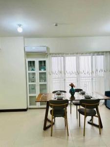a dining room with a table and chairs and a refrigerator at Vtan Condo in Manila