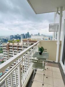 a balcony with a chair and a view of a city at Vtan Condo in Manila