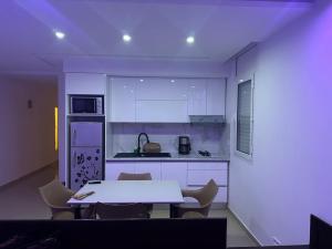 a kitchen with a table and chairs in a room at Dar Lebharr Kélibia in Kelibia