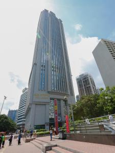 un edificio alto con gente caminando delante de él en Guangzhou Boman Apartment Zhengjia Huanshi Branch en Guangzhou