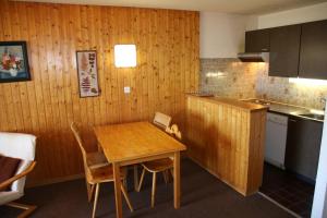 a kitchen with a wooden table and a table and chairs at Iris I 031 - CONFORTABLE apartment 6 pers in Veysonnaz