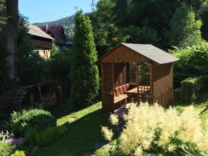 a wooden gazebo in the middle of a garden at U Evy Jarošové in Desná