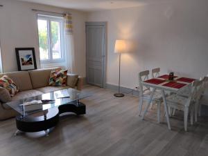a living room with a couch and a table at Le Comptoir du Canal in Fleurey-sur-Ouche