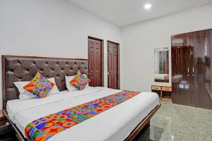 a bedroom with a large bed with a colorful blanket at FabHotel V9 - 800m From Calangute Beach in Marmagao