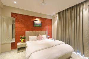 1 dormitorio con cama blanca y pared roja en The Marbella Beach Resort, en Diveagar 12 fotos más