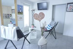 a living room with two chairs and a vase on the floor at Happiness in Sirnach