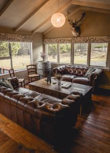 a living room with a leather couch and a table at Mt Potts Lodge in Ashburton Lakes
