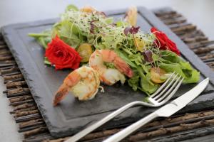 a plate of food with shrimp and a salad at Livin Mykonos Hotel in Mikonos