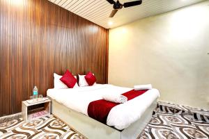 a bedroom with a bed with red and white pillows at Hotel Akasa View in Mumbai +4 photos