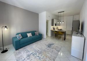 阿格里真托Subile Empedocle Apartment的带蓝色沙发的客厅和厨房