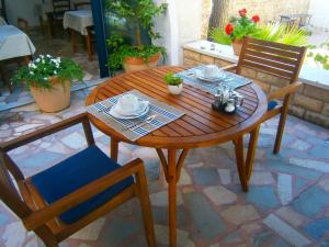 a wooden table and chairs on a patio at Bed & Breakfast Pansion Rade in Pirovac +24 photos