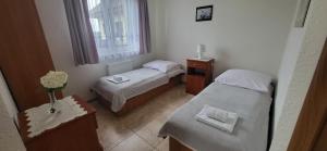 a small room with two beds and a window at Pod Lasem in Przewłoka