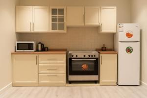 a kitchen with white cabinets and a stove and refrigerator at EMAAR Holiday Homes - Apartment 4 in Quai