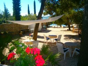 a patio with tables and chairs and flowers at Bed & Breakfast Pansion Rade in Pirovac