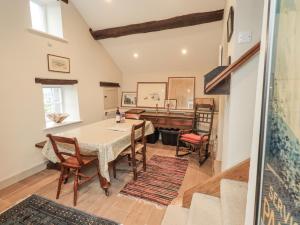 a dining room with a table and a piano at Old Cottage in Ulverston