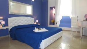 a blue bedroom with a king sized bed with a blue bedspread at Antico Casale B&B in Veglie