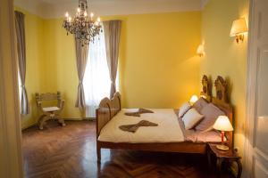 una camera da letto con un letto con pareti gialle e un lampadario a braccio di Apartment Bozic a Lovran (Laurana)