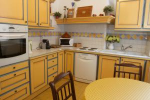 カンヌにあるChez Graceのキッチン(黄色のキャビネット、テーブル、椅子付)