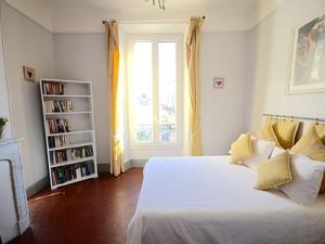 1 dormitorio con cama y estante para libros en Chez Grace, en Cannes