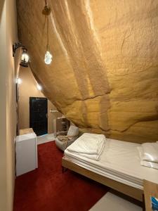 ein Bett in einem Zimmer mit einer Holzwand in der Unterkunft Red Mountain Suites in Al-'Ula