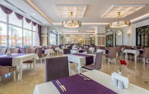 a restaurant with purple tables and chairs and windows at Mary Hotel Side in Side