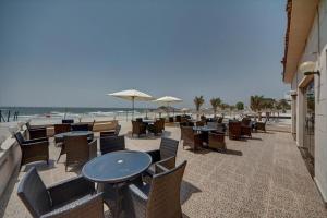 アジュマーンにあるLuxury 4 Bedroom Apt with Complimentary Access to Hotel Private Beach,GYM&Swimming Poolの- ビーチのパティオ(テーブル、椅子付)