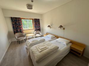 a bedroom with two beds and a desk and a window at Bjorliheimen Fjellhotell-Hotellrom in Bjorli +7 photos