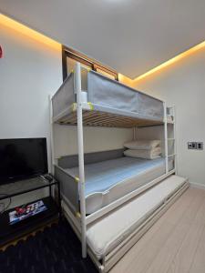 a bedroom with two bunk beds and a television at Santiago 2nd in Busan