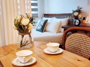 una mesa con dos platos y un jarrón con flores en 다온 영등포 Daon Youngdeungpo accommodation, en Seúl