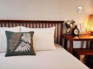 Cama con almohada y mesa con reloj en 다온 영등포 Daon Youngdeungpo accommodation, en Seúl