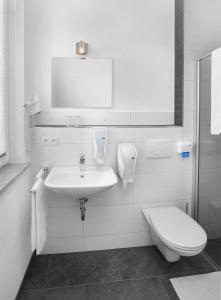 bagno bianco con lavandino e servizi igienici di Hotel 37 a Landshut