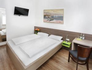 una camera con letto, scrivania e TV di Hotel 37 a Landshut
