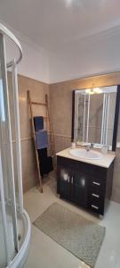 ein Badezimmer mit Waschbecken und Spiegel in der Unterkunft VillaMadeira Basement Apartment in Funchal in Funchal + 25 Fotos