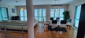 ein Wohnzimmer mit einer Couch und einem Tisch mit Stühlen in der Unterkunft VillaMadeira Basement Apartment in Funchal in Funchal