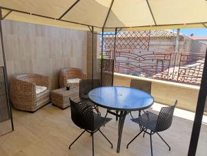 a patio with a table and chairs and a balcony at CasaMare Luxury Siderno in Siderno Marina