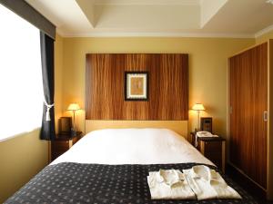 a bedroom with a bed with two towels on it at Hotel Monterey La Soeur Fukuoka in Fukuoka