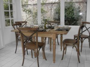 a wooden table with chairs and wine bottles on it at Genêts d'Armor in Pornichet