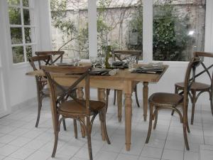 een houten tafel met stoelen en wijnflessen erop bij Genêts d'Armor in Pornichet