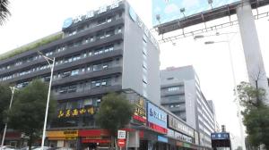 ShenzhenHanting Hotel Shenzhen Baoan Xixiang Taoyuanju的繁忙的城市街道上高大的白色建筑