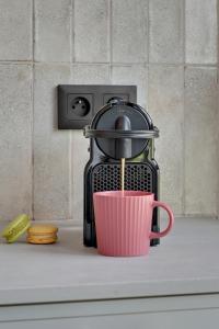 a coffee maker sitting on a counter with a pink cup at Żurawie - Food Hall, Parking & Stocznia by Downtown Apartments in Gdańsk