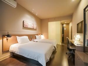 Ένα ή περισσότερα κρεβάτια σε δωμάτιο στο Jinjiang Inn Xiamen Jimei University Guomao