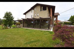 a house with large glass doors on a yard at Hotel Rioverde in Pralormo