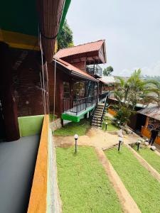 a view of a building with a porch and grass at Ella CityZing Hostel in Ella