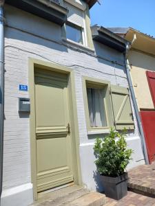 a house with a green door and two windows at Maison quartier typique in Auxi-le-Château